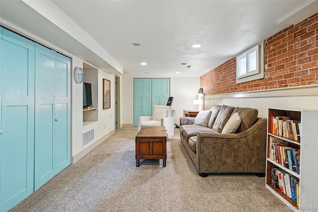 living room with recessed lighting, light carpet, brick wall, and visible vents