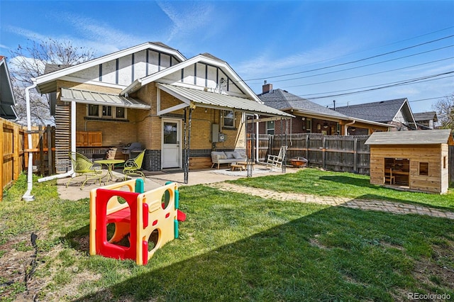 back of property with brick siding, an outdoor structure, a patio area, and a fenced backyard