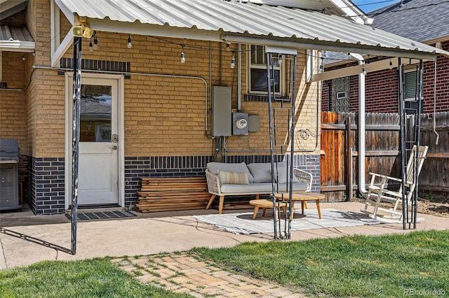 exterior space with metal roof, fence, and brick siding