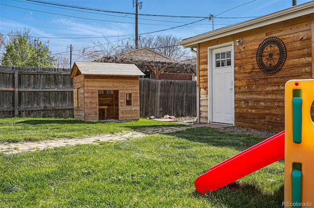 view of yard with a storage unit, fence private yard, and an outbuilding