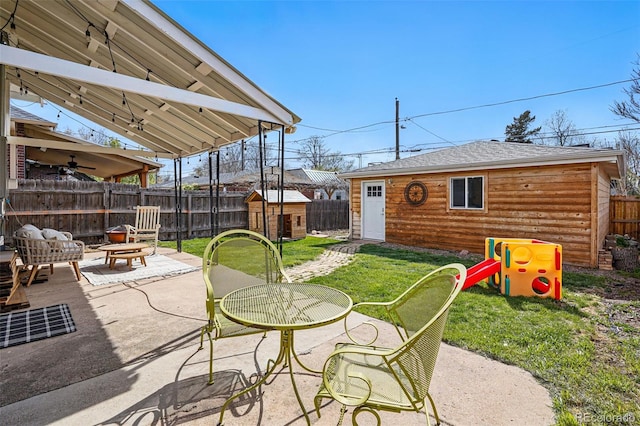 view of patio / terrace with an outbuilding, a ceiling fan, and a fenced backyard