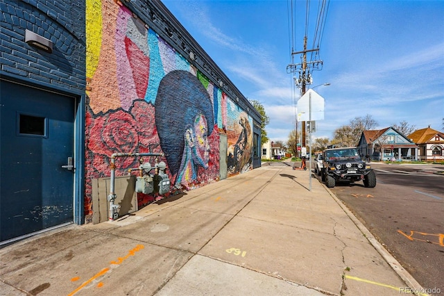 view of street featuring street lighting, curbs, sidewalks, and a residential view