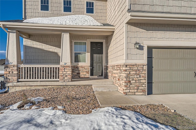 snow covered property entrance featuring a porch