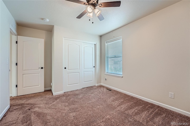 unfurnished bedroom featuring a textured ceiling, carpet floors, a closet, and ceiling fan