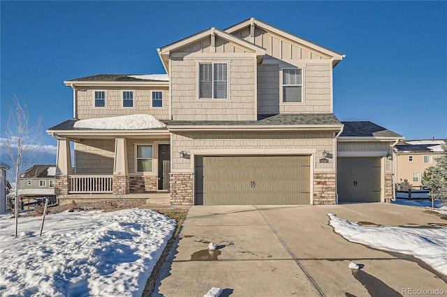 craftsman inspired home with stone siding, board and batten siding, a porch, and concrete driveway