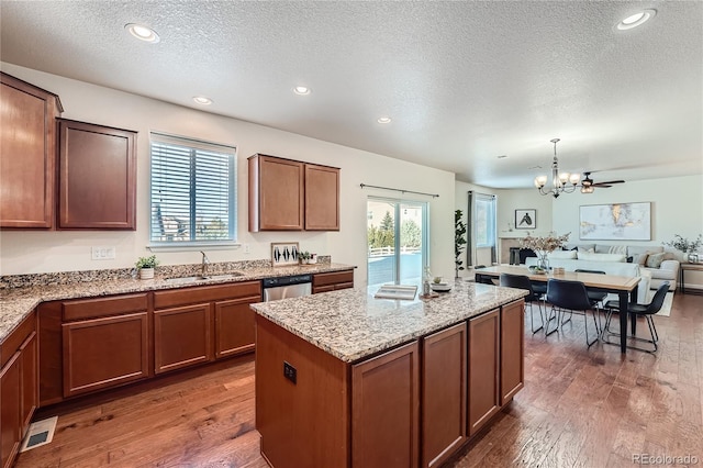 kitchen with open floor plan, dishwasher, hardwood / wood-style floors, and a sink