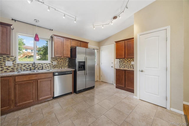 kitchen with lofted ceiling, sink, light tile patterned flooring, appliances with stainless steel finishes, and backsplash