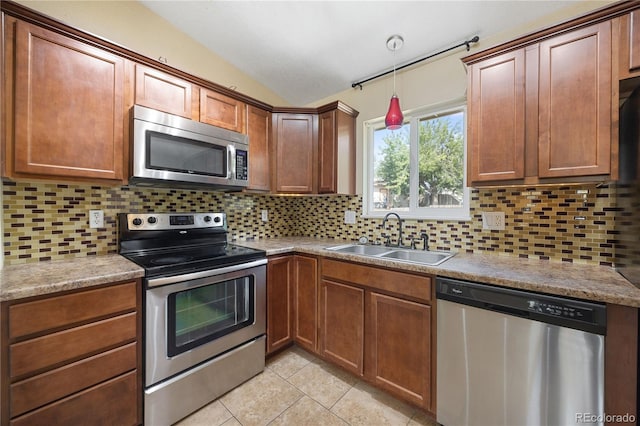 kitchen featuring decorative backsplash, vaulted ceiling, sink, stainless steel appliances, and light tile patterned floors