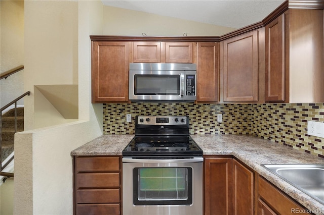 kitchen featuring tasteful backsplash, appliances with stainless steel finishes, and lofted ceiling