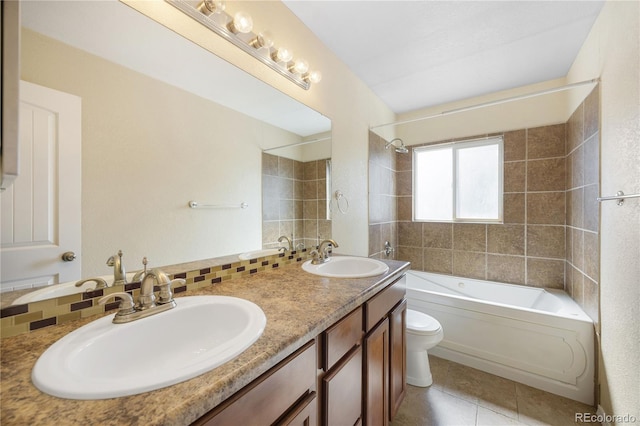 full bathroom featuring tile patterned floors, vanity, toilet, and tiled shower / bath combo