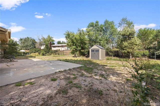 view of yard featuring a storage unit and a patio area