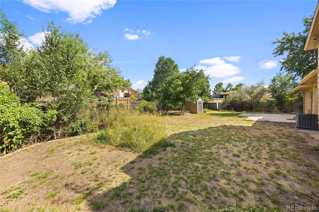 view of yard with a storage shed and central air condition unit