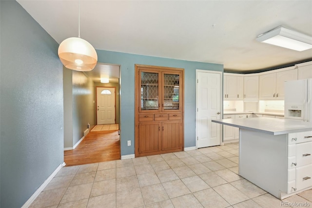 3784 Swadley St, Wheat Ridge, CO 80033 - kitchen featuring light countertops, white cabinetry, light tile patterned floors, and decorative light fixtures