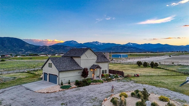 10757 Vista Farms Ct, Salida, CO 81201 - view of front of property featuring stucco siding, a mountain view, concrete driveway, and a view of rural / pastoral area