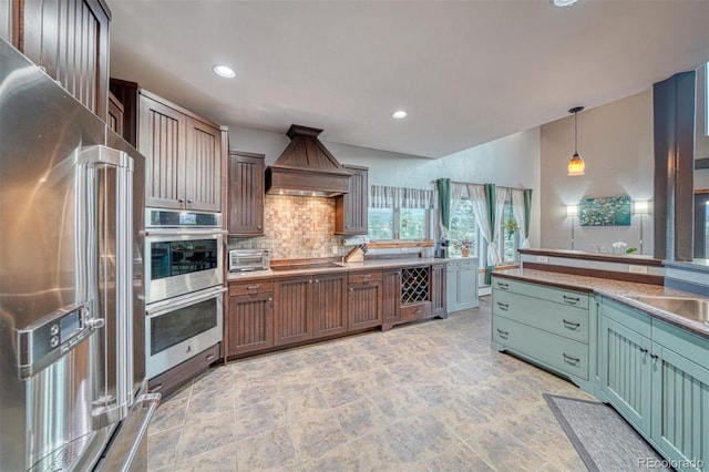 10757 Vista Farms Ct, Salida, CO 81201 - kitchen featuring appliances with stainless steel finishes, custom exhaust hood, tasteful backsplash, recessed lighting, and hanging light fixtures