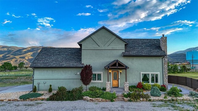 10757 Vista Farms Ct, Salida, CO 81201 - view of front facade featuring a chimney, stucco siding, a mountain view, and roof with shingles