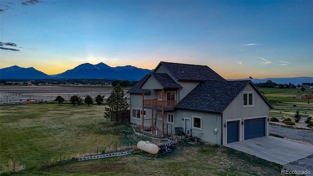 10757 Vista Farms Ct, Salida, CO 81201 - view of front of home with a balcony, stucco siding, concrete driveway, a mountain view, and a front lawn