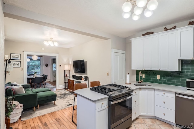1612 N High St, Denver, CO 80218 - kitchen with stainless steel appliances, a chandelier, open floor plan, and light countertops