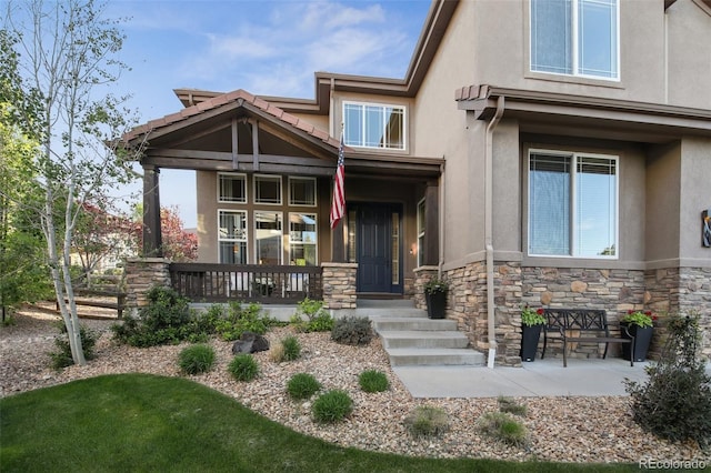 17490 W 67th Ave, Arvada, CO 80007 - view of front facade with stucco siding, stone siding, and covered porch