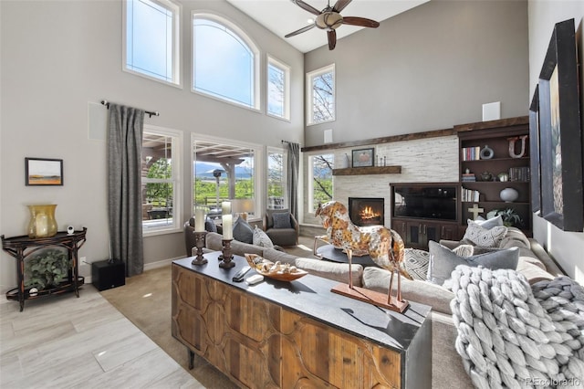 17490 W 67th Ave, Arvada, CO 80007 - living area featuring a towering ceiling, ceiling fan, baseboards, and a fireplace