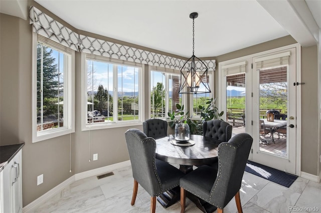 17490 W 67th Ave, Arvada, CO 80007 - dining space with baseboards, light marble finish floors, and a chandelier