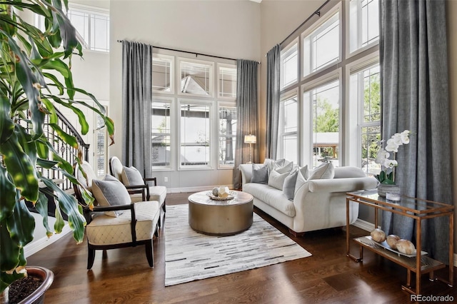 17490 W 67th Ave, Arvada, CO 80007 - living area featuring a towering ceiling, dark wood-type flooring, and baseboards
