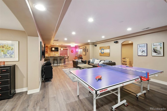 17490 W 67th Ave, Arvada, CO 80007 - game room with wood finished floors, bar, arched walkways, recessed lighting, and baseboards
