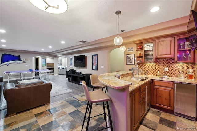 17490 W 67th Ave, Arvada, CO 80007 - kitchen with arched walkways, decorative columns, recessed lighting, open floor plan, and a kitchen breakfast bar