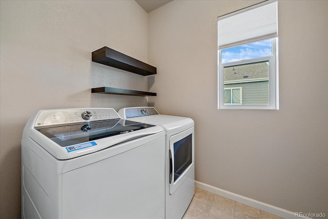 clothes washing area with washer and dryer and light tile patterned floors