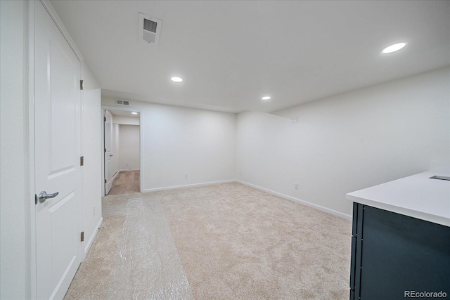 basement featuring light colored carpet