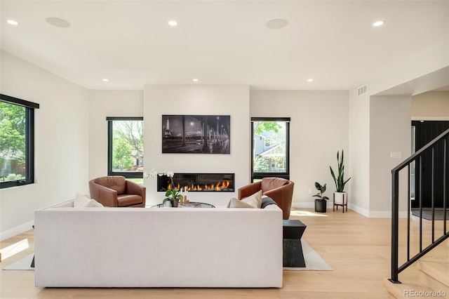 1462 S Vine St, Denver, CO 80210 - living area with a glass covered fireplace, stairs, plenty of natural light, light wood-style flooring, and recessed lighting