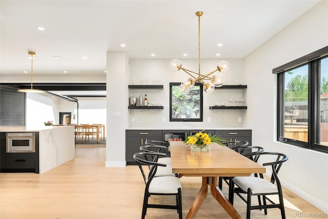 1462 S Vine St, Denver, CO 80210 - dining area featuring light wood-style floors, a bar, recessed lighting, and a chandelier