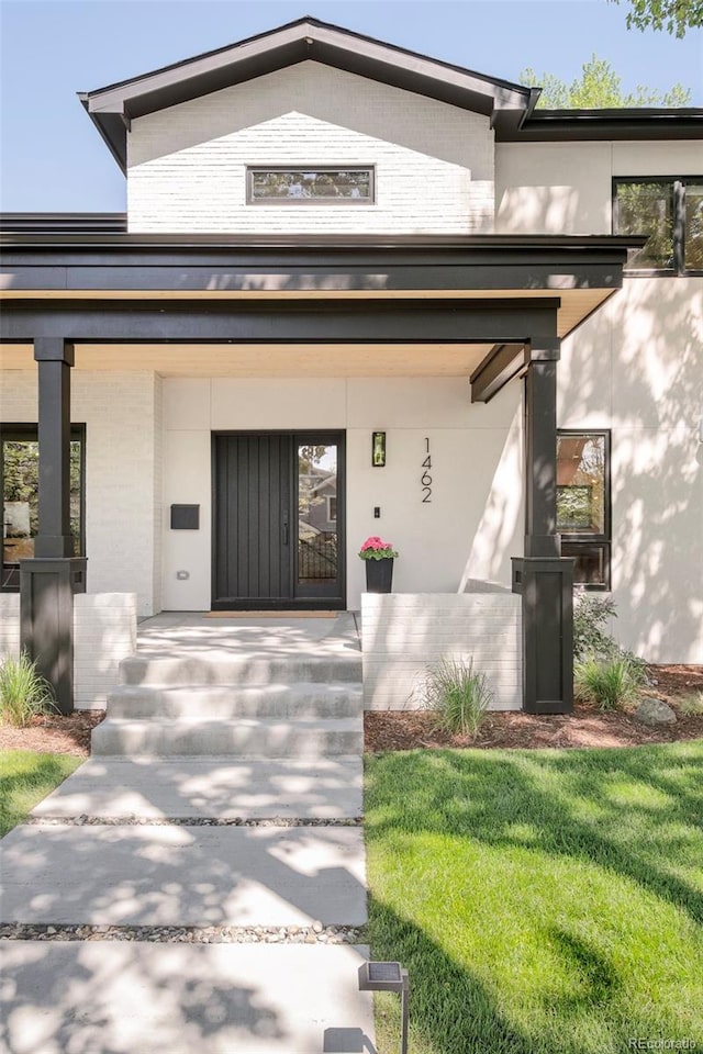 1462 S Vine St, Denver, CO 80210 - view of front of home with a porch, brick siding, and a front lawn
