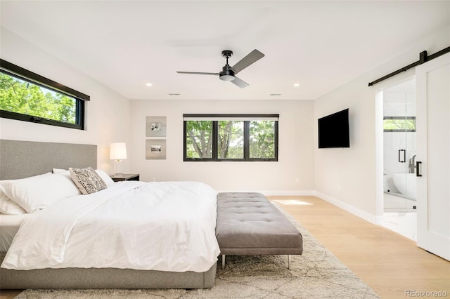 1462 S Vine St, Denver, CO 80210 - bedroom with light wood-style floors, a barn door, multiple windows, recessed lighting, and ensuite bathroom