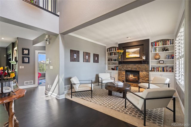 7963 S Valleyhead Way, Aurora, CO 80016 - living area featuring a fireplace, baseboards, wood finished floors, ornamental molding, and built in shelves