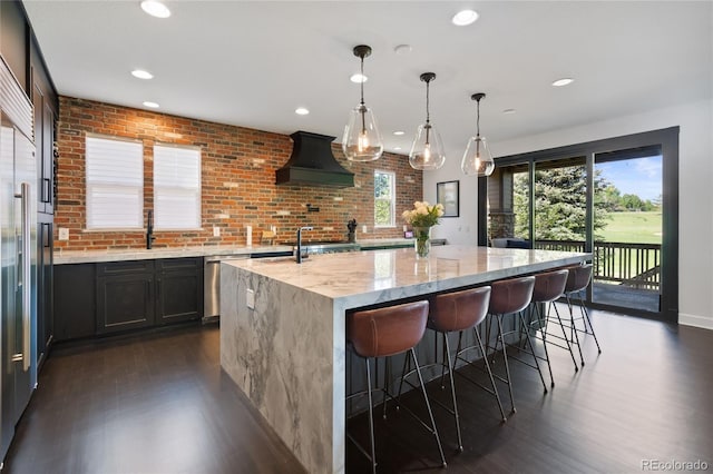 7963 S Valleyhead Way, Aurora, CO 80016 - kitchen featuring premium range hood, dark wood-style floors, light stone counters, a spacious island, and a breakfast bar area