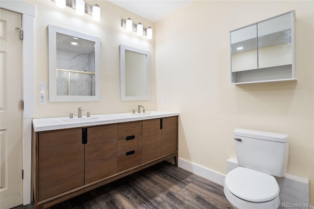 7963 S Valleyhead Way, Aurora, CO 80016 - bathroom featuring baseboards, wood finished floors, double vanity, an enclosed shower, and toilet