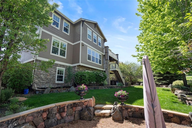 7963 S Valleyhead Way, Aurora, CO 80016 - back of property with stone siding, a lawn, and stairway