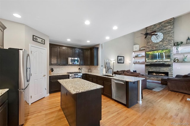 20460 Oakbrook Ln, Parker, CO 80138 - kitchen featuring stainless steel appliances, a sink, open floor plan, dark brown cabinetry, and recessed lighting