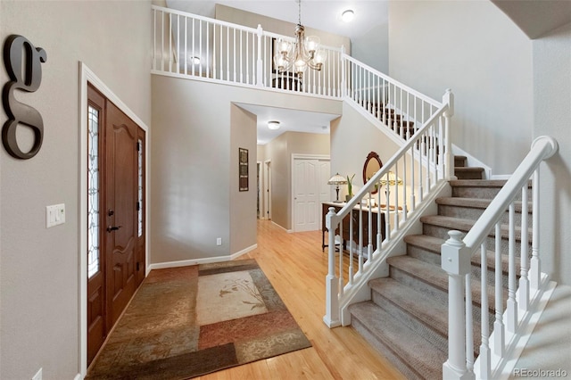 20460 Oakbrook Ln, Parker, CO 80138 - foyer entrance with a towering ceiling, wood finished floors, stairway, a chandelier, and baseboards