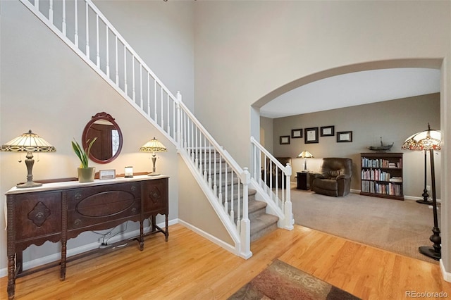 20460 Oakbrook Ln, Parker, CO 80138 - staircase with arched walkways, wood finished floors, baseboards, and a high ceiling