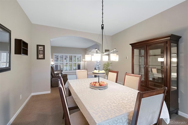 20460 Oakbrook Ln, Parker, CO 80138 - dining space with arched walkways, baseboards, a chandelier, and dark colored carpet