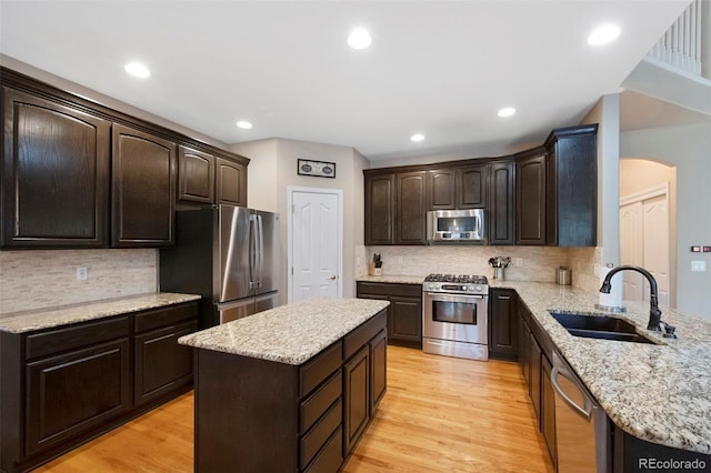 20460 Oakbrook Ln, Parker, CO 80138 - kitchen with appliances with stainless steel finishes, a sink, dark brown cabinets, arched walkways, and recessed lighting