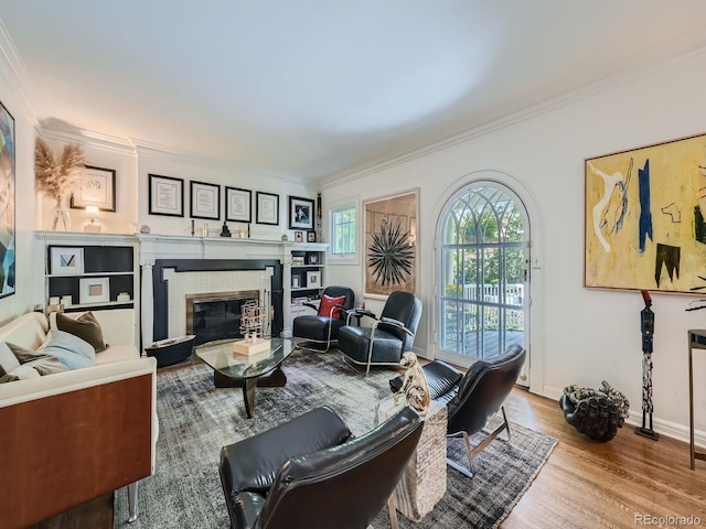 living room with ornamental molding, a brick fireplace, and light hardwood / wood-style floors