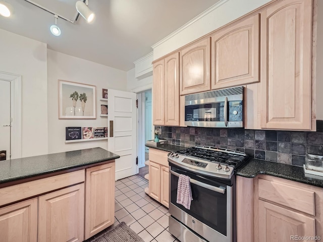 kitchen with track lighting, tasteful backsplash, stainless steel appliances, light tile patterned floors, and light brown cabinetry