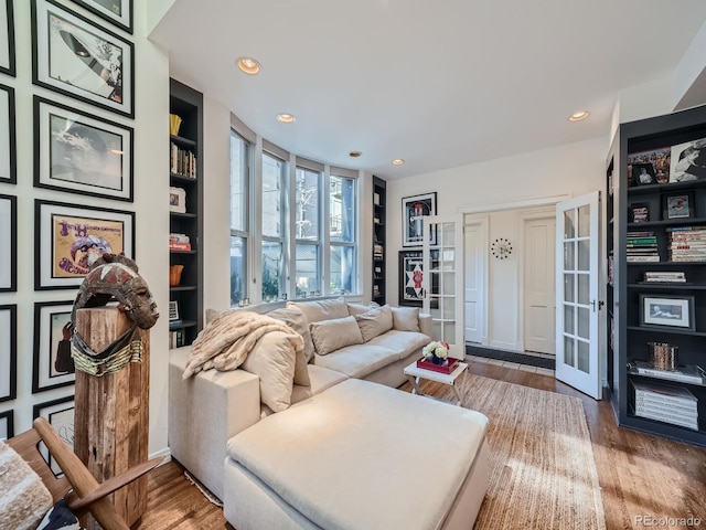 living room with french doors, hardwood / wood-style floors, and built in shelves