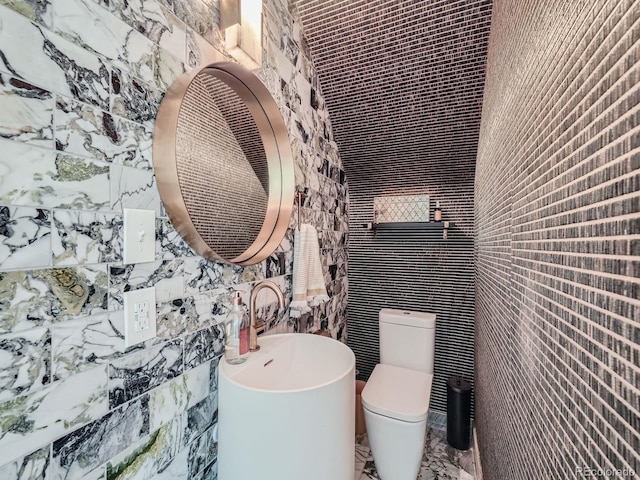 bathroom with tile walls and toilet