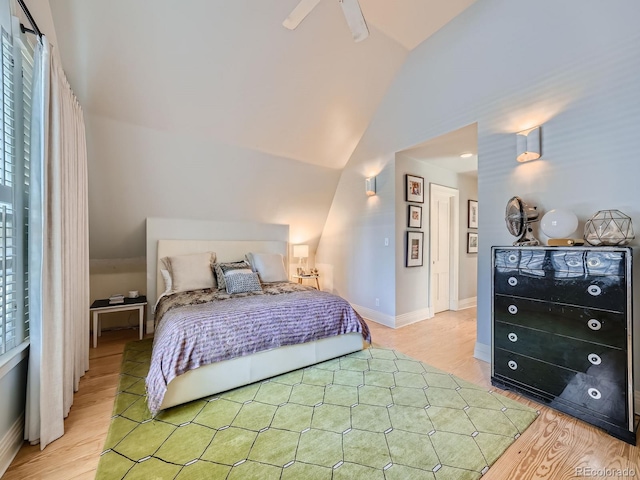 bedroom featuring light wood-type flooring, vaulted ceiling, and ceiling fan