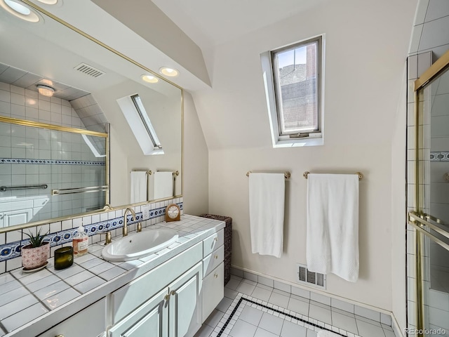 bathroom with lofted ceiling with skylight, vanity, tile patterned flooring, and an enclosed shower