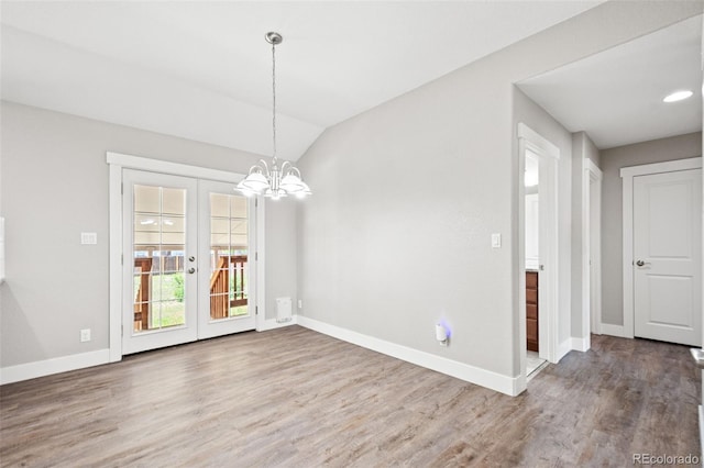 335 N 11th Ave, Brighton, CO 80601 - unfurnished dining area with wood finished floors, baseboards, french doors, vaulted ceiling, and a chandelier